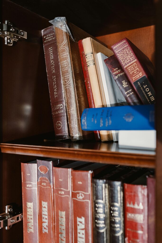 Collection of various books on a wooden bookshelf, featuring titles in multiple languages.